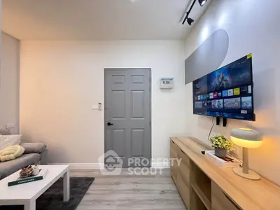 Modern living room with sleek decor and wall-mounted TV, perfect for entertainment and relaxation.