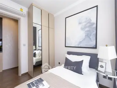 Modern bedroom with stylish decor and mirrored wardrobe