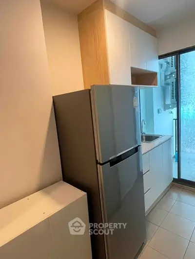 Modern compact kitchen with sleek fridge and minimalist design