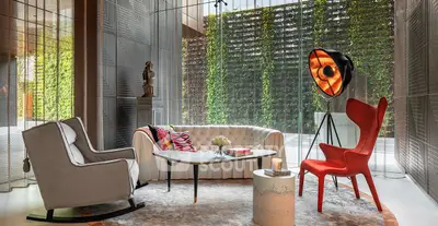 Luxurious modern living room with stylish furniture and floor-to-ceiling windows overlooking lush greenery.