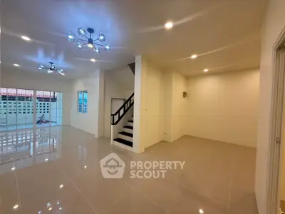 Spacious modern living room with elegant lighting and staircase