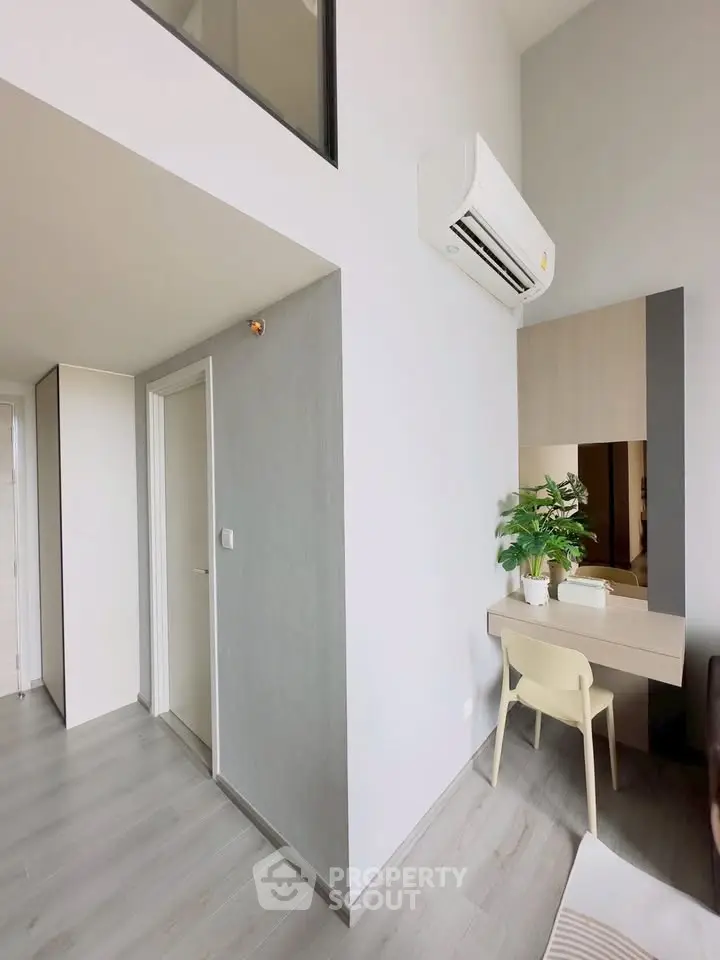 Modern apartment interior with sleek design and air conditioning, featuring a stylish study nook.