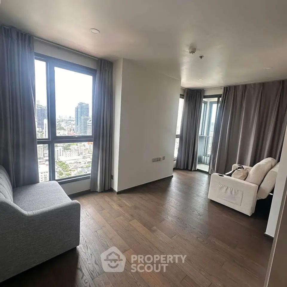 Spacious living room with city view and modern furnishings in high-rise apartment