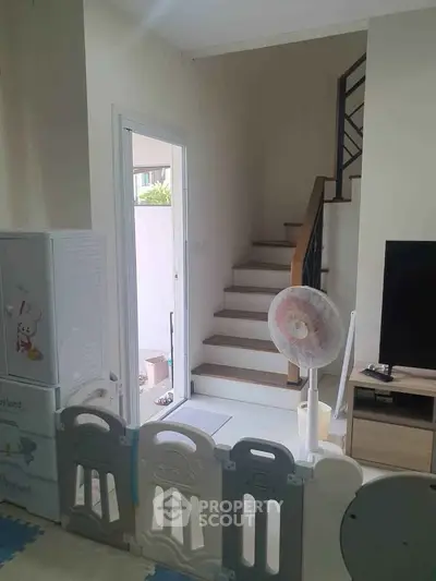 Charming family-friendly living space with staircase and child safety gate