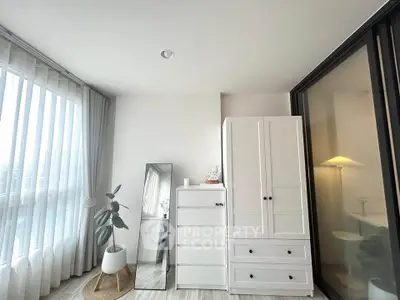 Bright and modern bedroom with white furniture and large window, perfect for serene living.