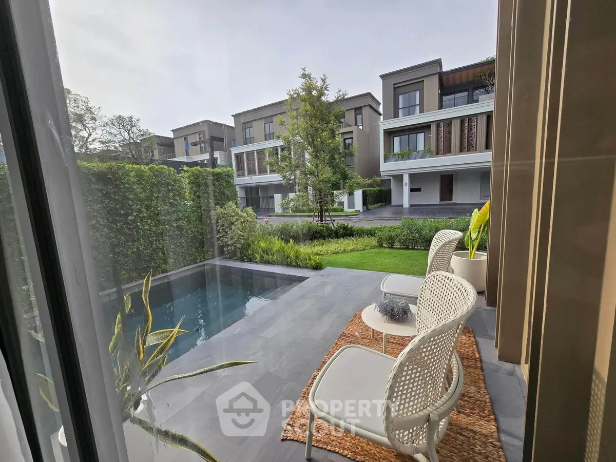 Luxurious garden view with private pool and modern patio seating in upscale residential area.