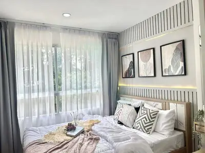 Bright and cozy bedroom with modern decor and large window view.