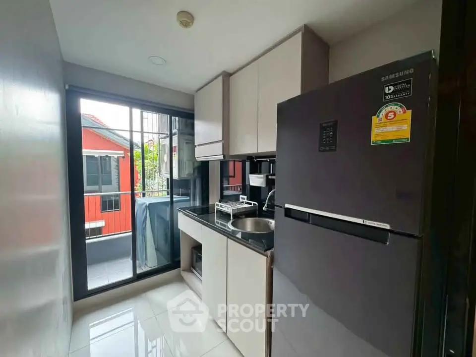 Modern kitchen with sleek appliances and balcony view in a stylish apartment.