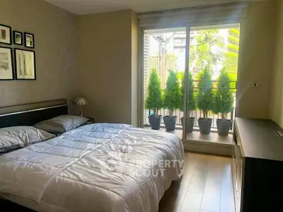 Cozy bedroom with large window and balcony view, perfect for relaxation.