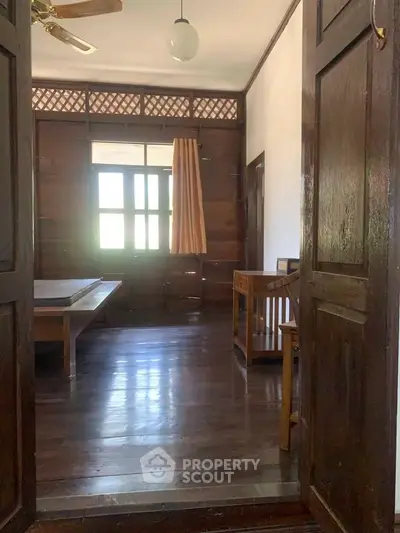 Charming wooden interior with natural light and classic furnishings, perfect for a cozy living space.
