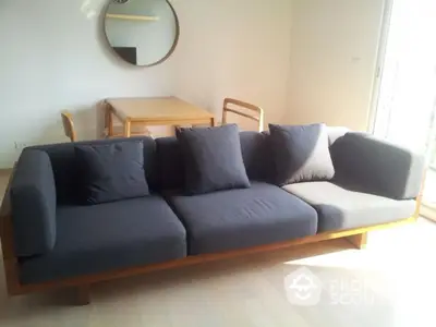 Modern living room with stylish sofa and dining table in bright natural light.