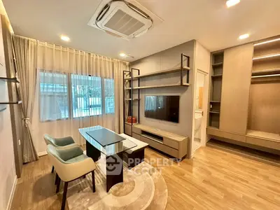 Modern living room with stylish furniture and built-in storage, featuring a sleek entertainment center.