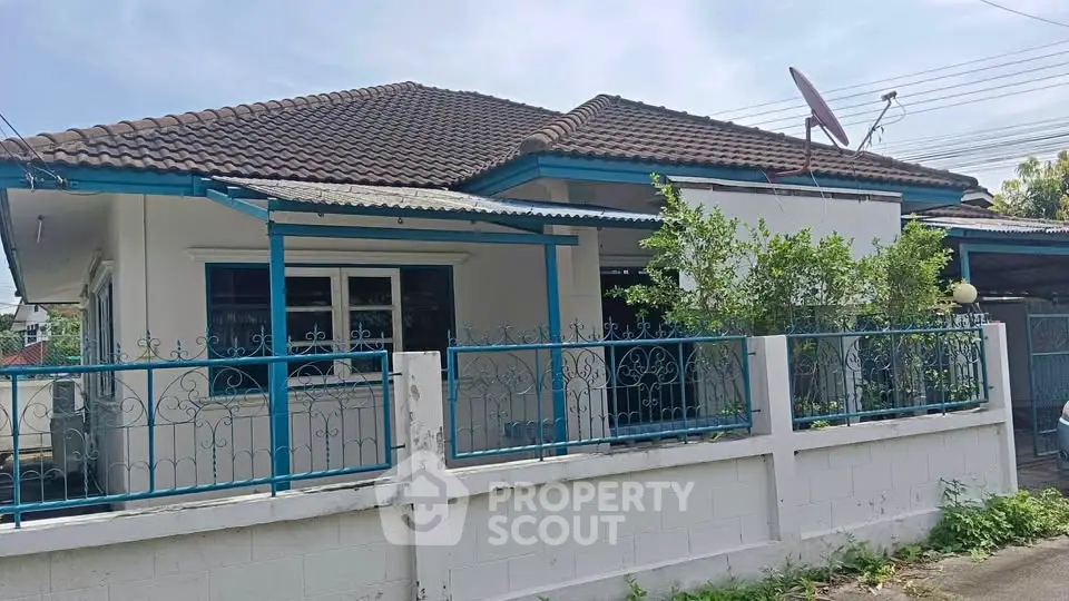 Charming single-story house with tiled roof and fenced yard, perfect for family living.