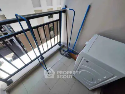 Compact balcony with washing machine and drying rack in modern apartment