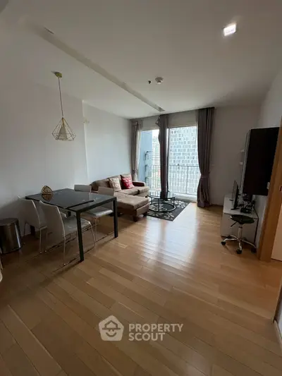 Modern living room with wooden flooring and large windows offering city view