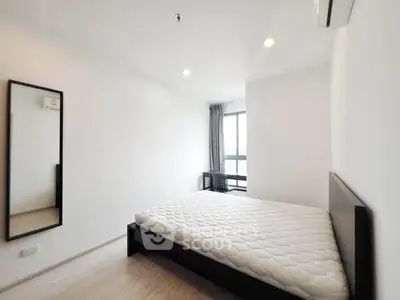 Spacious modern bedroom with large window and minimalist decor in a high-rise apartment.