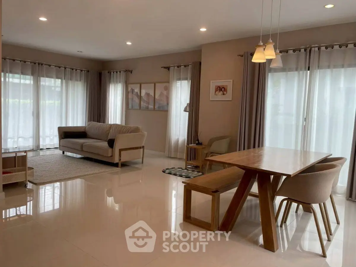 Spacious modern living room with elegant dining area and natural light.