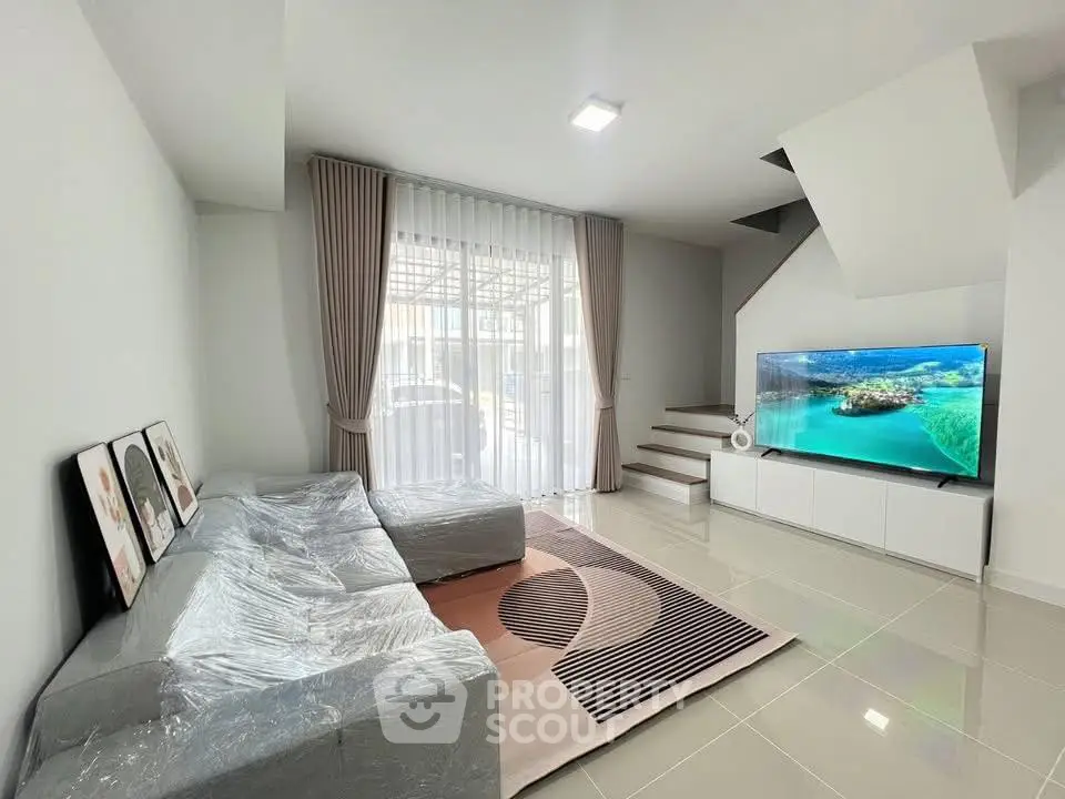 Modern living room with sleek design and large TV, perfect for relaxation.