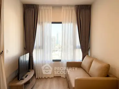 Cozy living room with city view, featuring a beige sofa and modern TV setup.