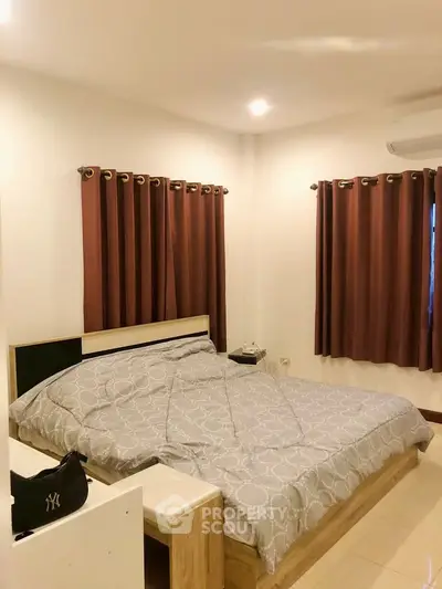 Cozy bedroom with modern decor and natural lighting, perfect for relaxation.
