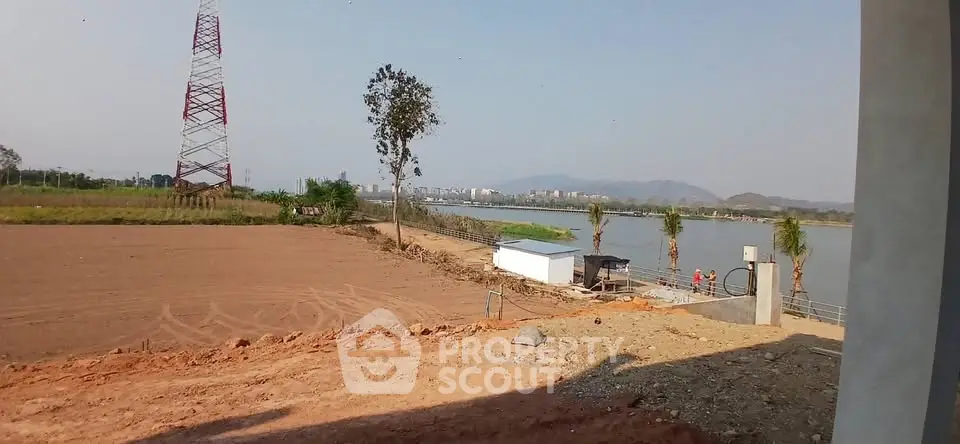 Scenic riverfront land with distant city view, ideal for development.