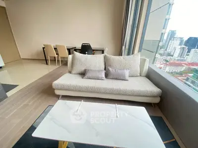 Modern living room with city view, stylish sofa, and elegant dining area in high-rise apartment.
