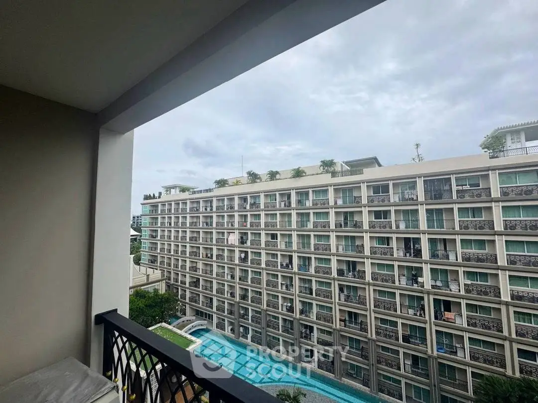 Modern apartment building with pool view from balcony, showcasing urban living and amenities.