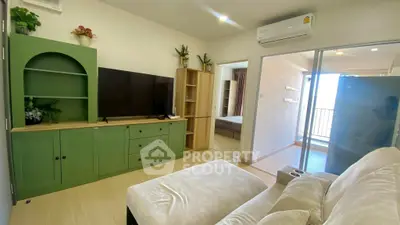Cozy living room with green cabinetry and modern decor, featuring a large TV and comfortable seating.