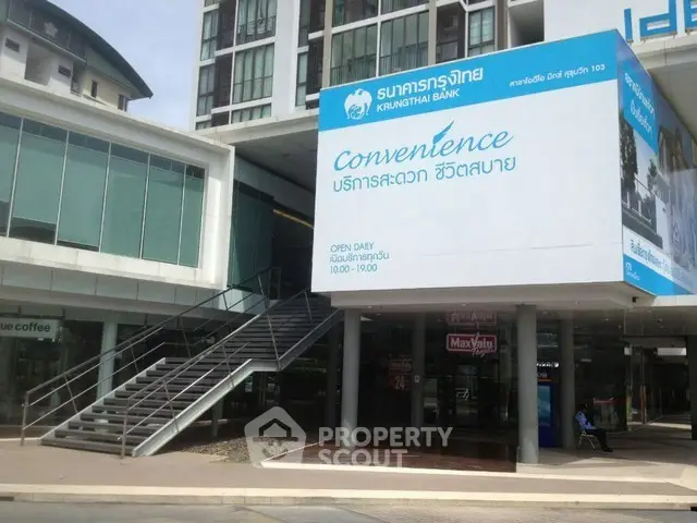 Modern commercial building with bank signage and glass facade, ideal for business opportunities.