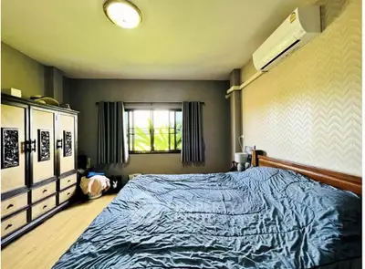 Spacious bedroom with large window and air conditioning unit