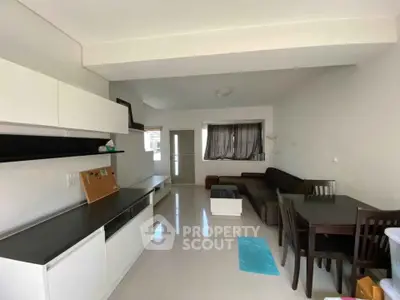 Modern living room with sleek furniture and dining area, perfect for urban living.