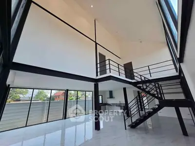 Stunning modern loft with high ceilings and sleek staircase, offering an open and airy living space.