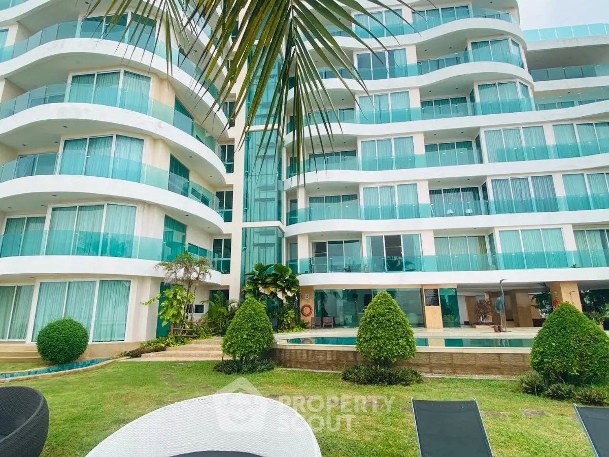 Luxurious modern apartment building with glass balconies and lush garden view.