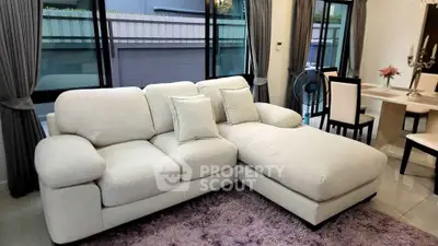 Elegant living room with plush sectional sofa and dining area, perfect for modern comfort and style.