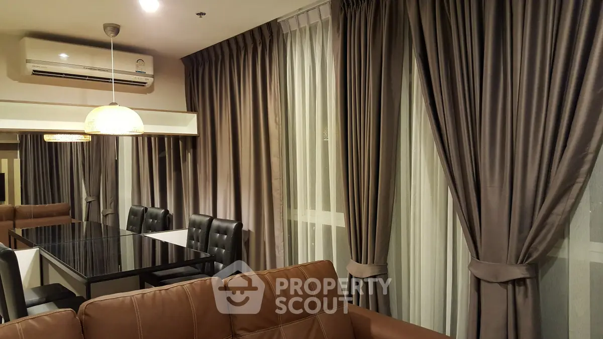 Elegant living room with modern dining area and luxurious curtains