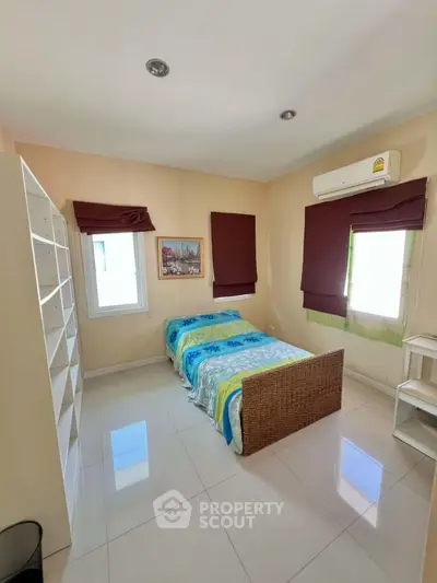 Cozy bedroom with single bed, air conditioning, and ample natural light