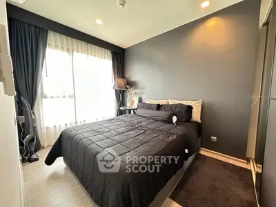 Modern bedroom with sleek black decor and large window for natural light.