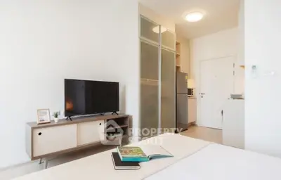 Modern studio apartment with sleek interior design and compact kitchen area.