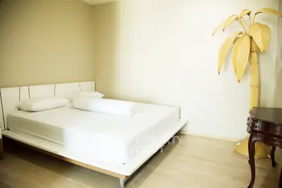 Spacious bedroom with minimalist decor and unique palm tree lamp