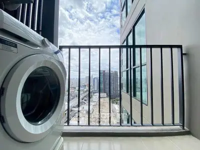 Modern high-rise balcony with city view and washing machine, perfect for urban living.