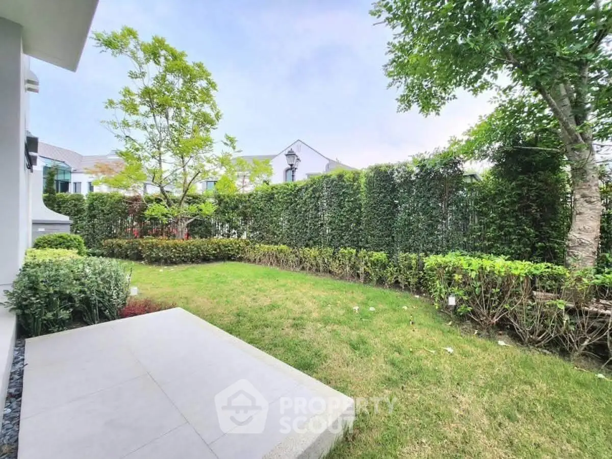 Charming garden view with lush greenery and patio in modern residential area.