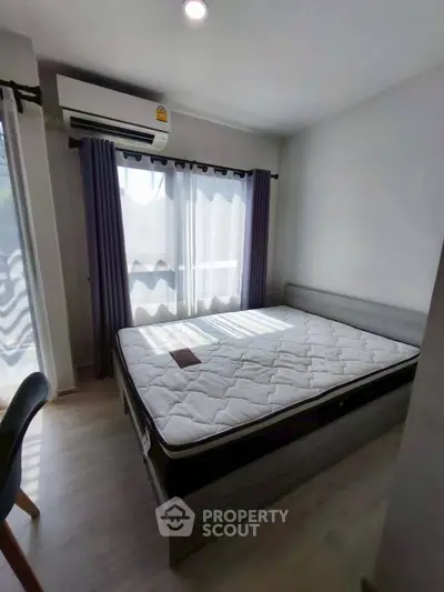 Cozy bedroom with natural light, featuring a comfortable bed and modern decor, perfect for relaxation.