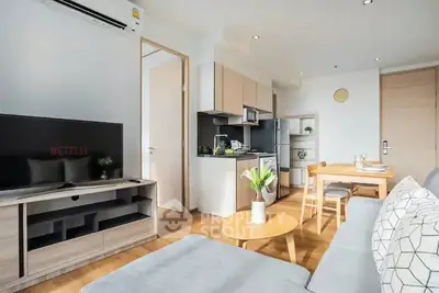 Modern open-plan living room with kitchen, stylish decor, and natural light.