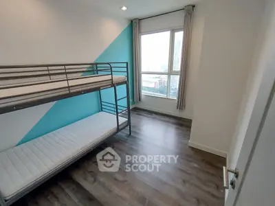 Modern bedroom with bunk bed and city view, featuring stylish blue accent wall and sleek flooring.