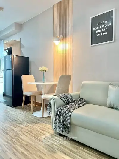 Modern living room with stylish decor, cozy sofa, dining area, and sleek kitchen appliances.