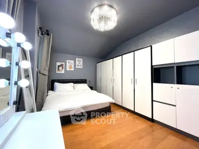 Spacious modern bedroom with elegant lighting and ample storage space.