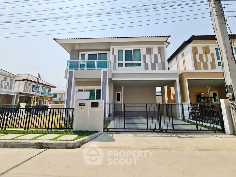 Modern two-story house with gated driveway and contemporary design.