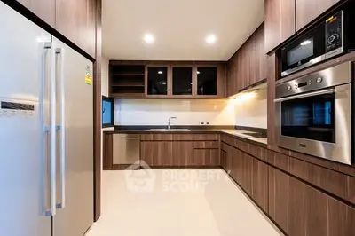 Modern kitchen with sleek wooden cabinetry and built-in appliances