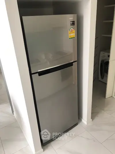 Modern kitchen with sleek stainless steel fridge and washing machine