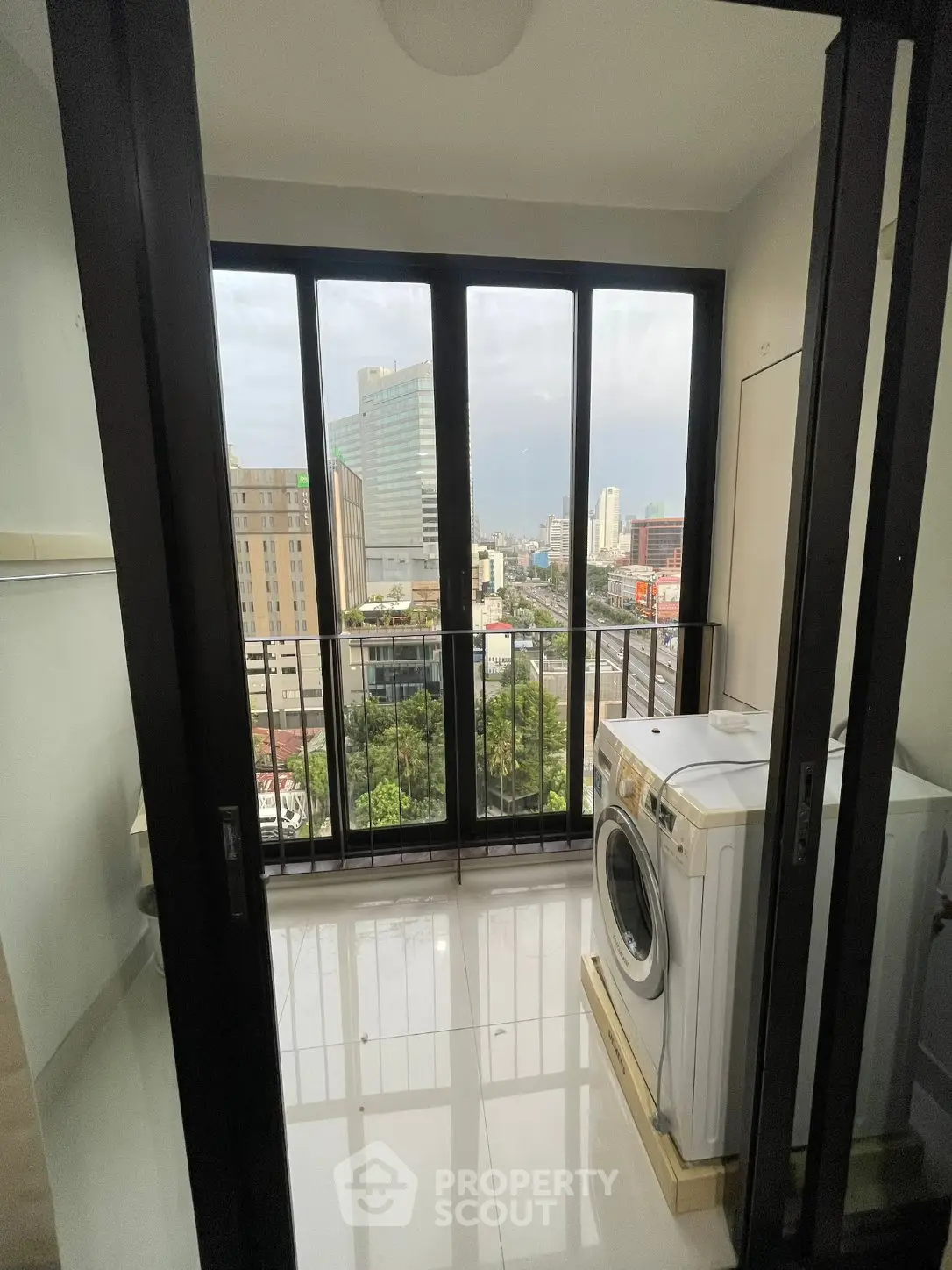 Modern apartment balcony with city view and washing machine